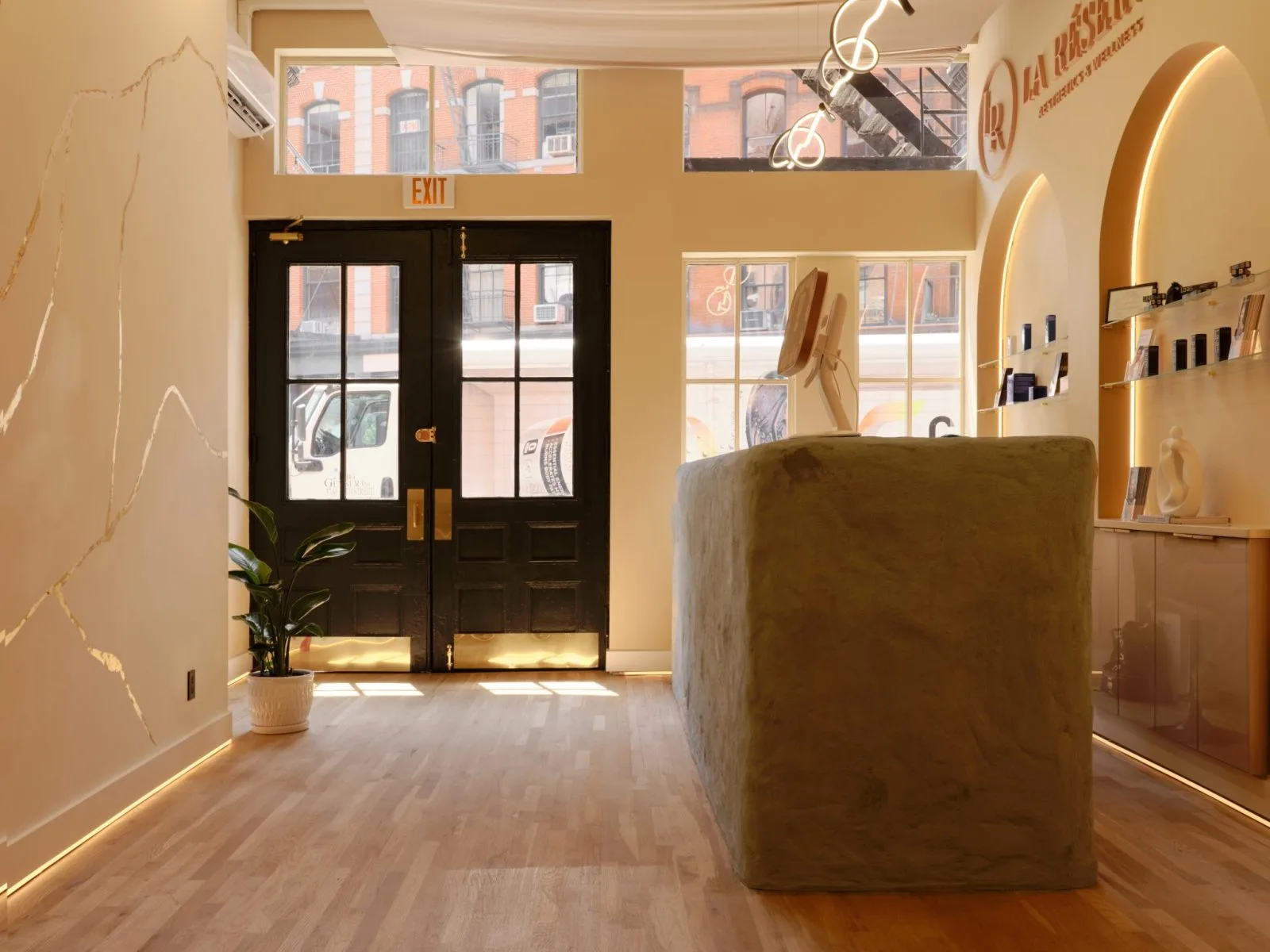 La Reservé Aesthetics and wellness Soho medspa reception area with black entry doors, warm cream walls, and product displays